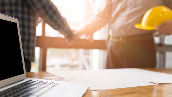 architects shaking hands, hard hat, laptop, construction