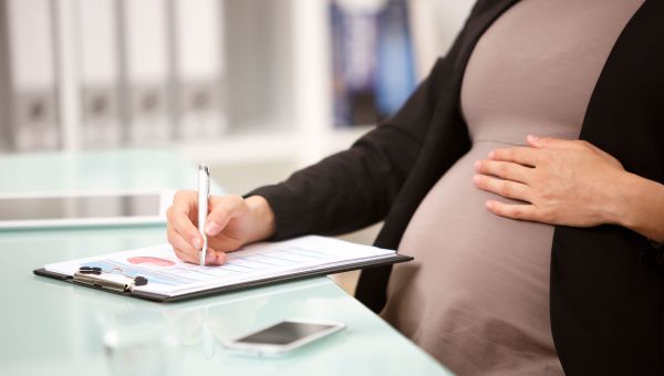 pregnant woman, clipboard, filling out a form, desk