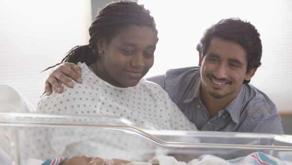 father to be, mother to be, hospital room, delivery room, woman laying down in bed