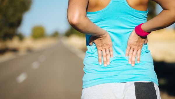 back pain, woman pressing hands against her back