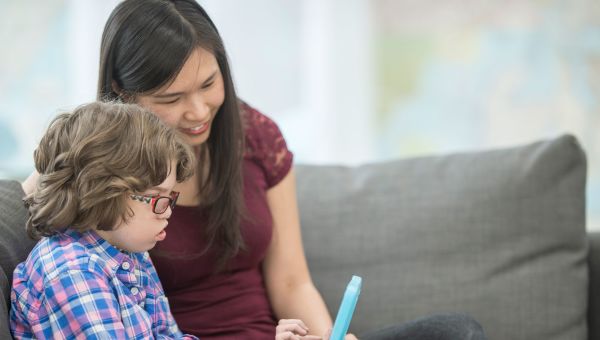 woman using tablet with child who has down syndrome