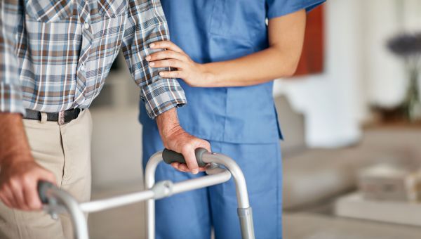 nurse assisting patient using a walker
