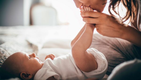 Woman kissing her infant's feet