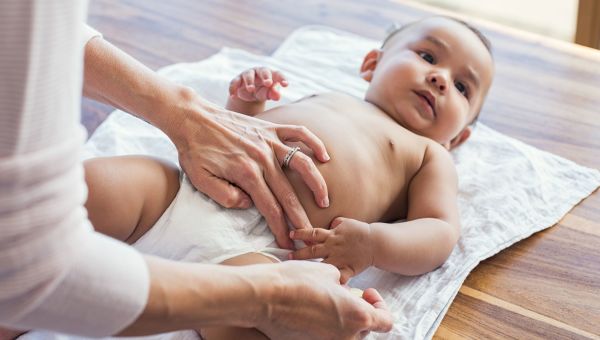 Woman rubbing baby's tummy