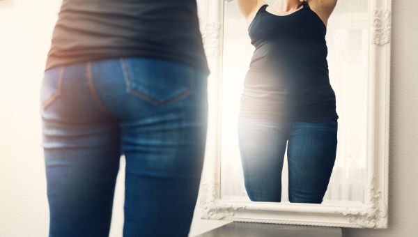 Woman looking at her reflection in the mirror