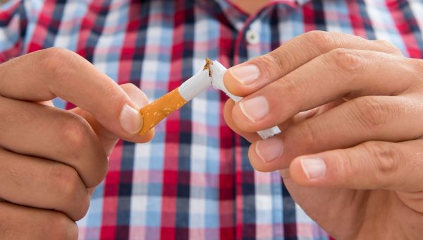 Man breaking a cigarette in half