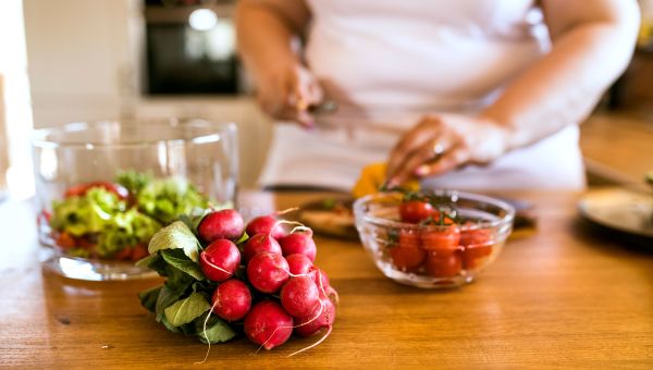 Someone chopping up fresh vegetables and fruits