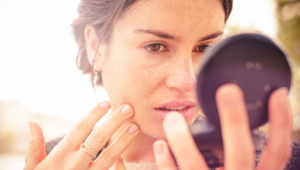 woman looking at complexion