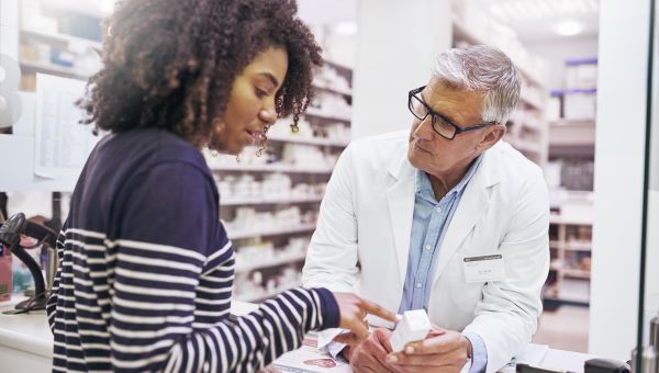 young woman speaking with pharmacist