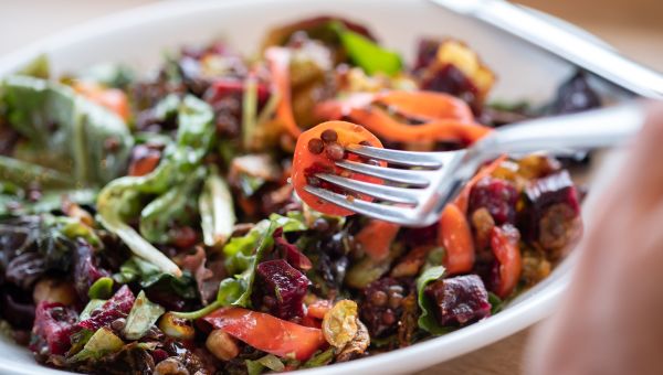 Healthy meal and fork with carrots tomatoes lentils