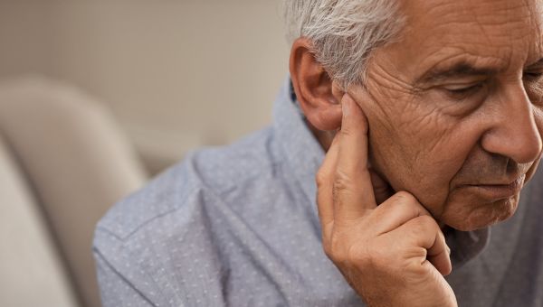 elderly man touching his ear