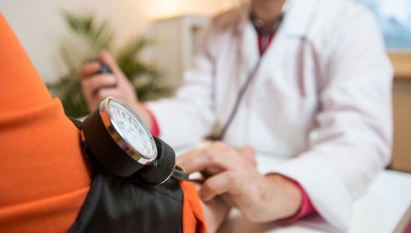 Doctor checking patient's blood pressure