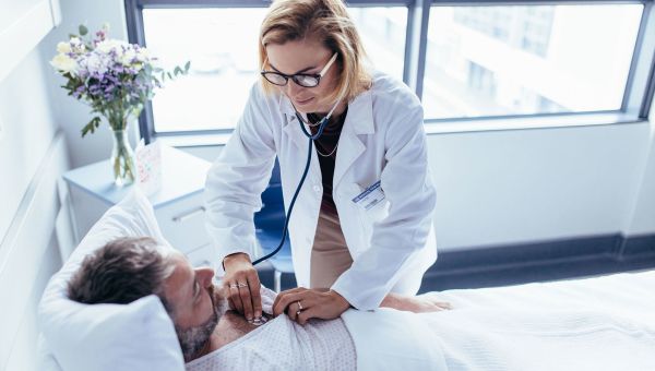 doctor checking patient's heartbeat