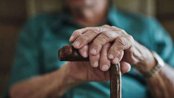 Senior man resting his hands on walking cane