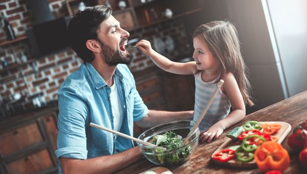 girl feeding her father