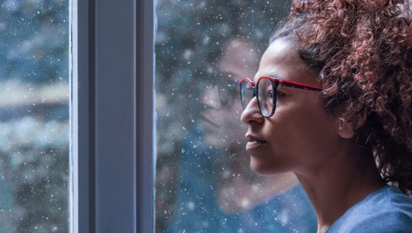 young woman staring out the window