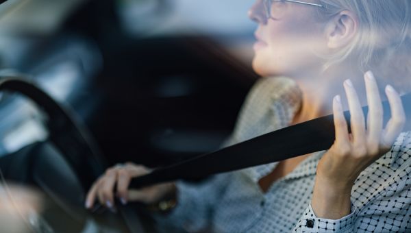 young woman putting on her seatbelt