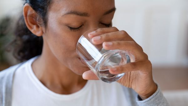 A woman drinking a glass of water.