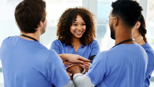 group of nurses of different ethnicities gather in a circle