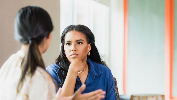 a young woman speaks with her female therapist