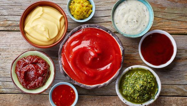 Small bowls filled with ketchup, ranch, relish, and other condiments that contain hidden sugars.
