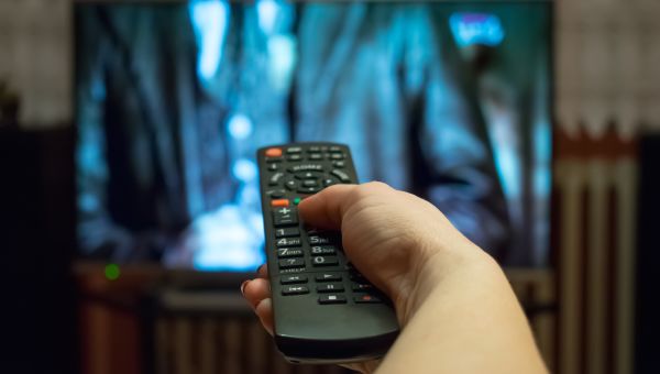 hand with remote watching television