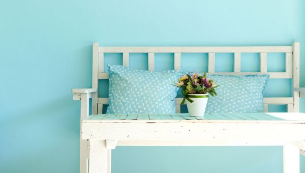 White bench and table surrounded by blue decor.