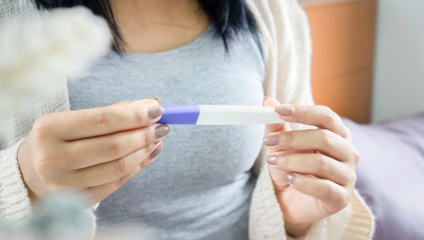 a woman reads the results of a home pregnancy test