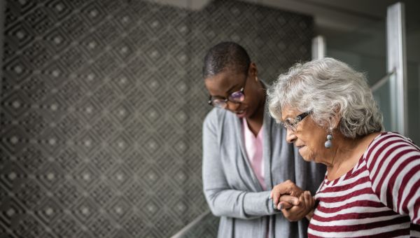 nurse helping senior woman on stairs