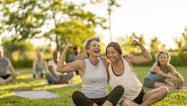 an older white woman and younger Asian woman celebrate after doing a yoga class