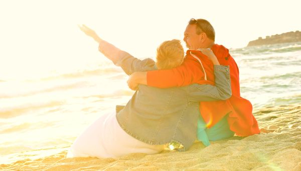 Happy elderly couple on beach.