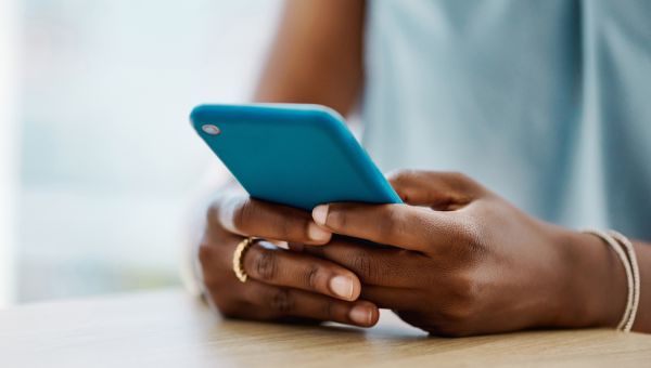 A woman using a phone to reschedule her gynecologist appointment