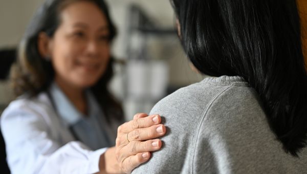 woman doctor comforts woman patient