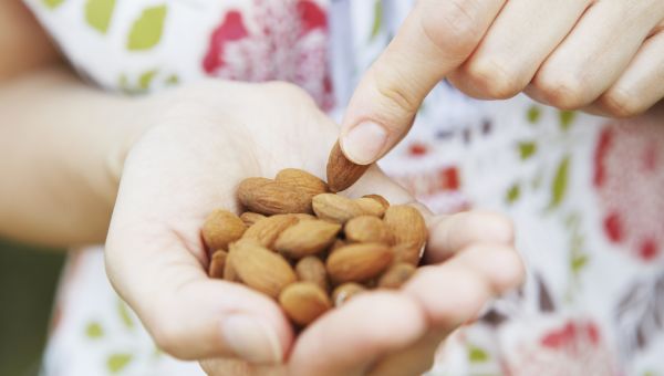 closeup of woman's hands holding almonds