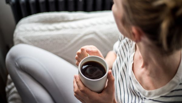 Young woman holds coffee cup