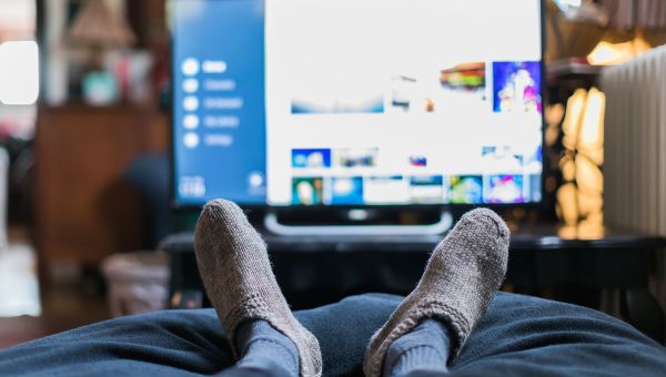 man watching television in bed