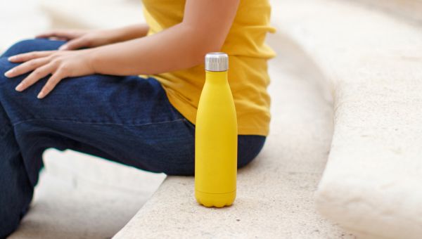woman in yellow with yellow water bottle