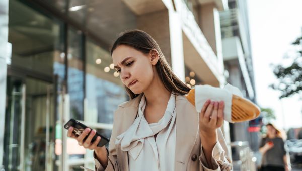 young woman eating while walking on lunch break