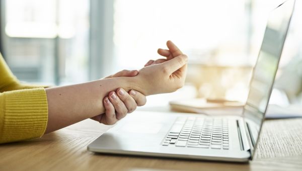 woman clutching her aching wrist