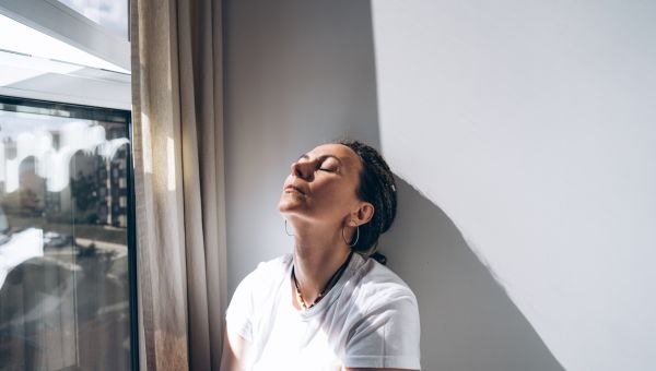 a middle aged white woman tries to soothe her anger by sitting against a wall and breathing