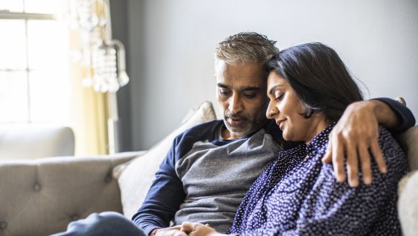 a couple in their early 40s sitting on a couch
