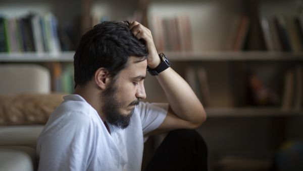 exhausted man sitting by a couch