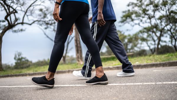 closeup from waist-down of couple walking at park