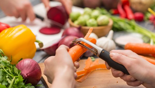 Person peeling carrots in the kitchen