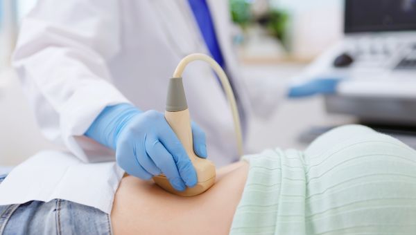 Healthcare provider doing ultrasound of someone's lower abdomen