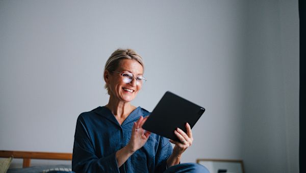 woman in bed keeping track of sleep on tablet