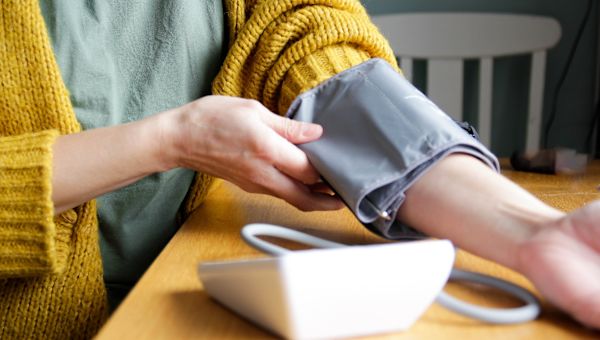 woman taking blood pressure reading at home