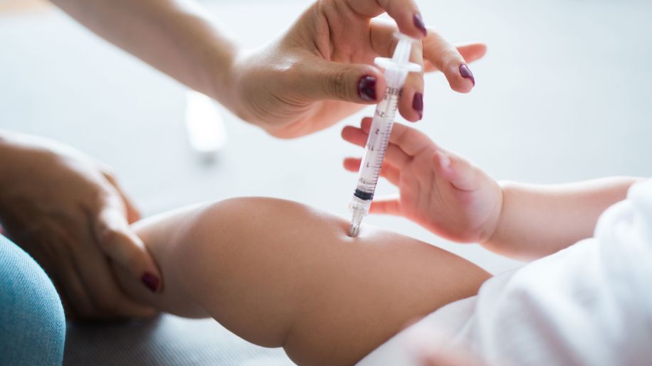 Nurse administering vaccine to an infant