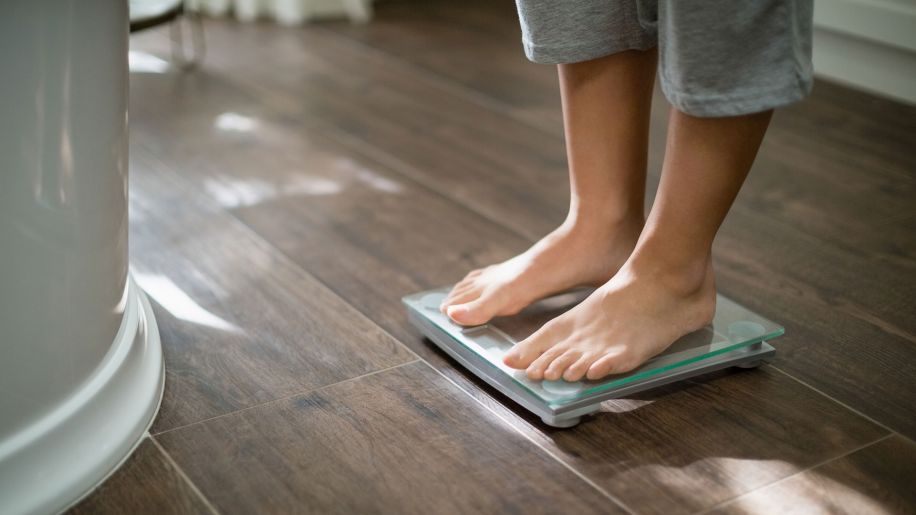 woman standing on weight scale