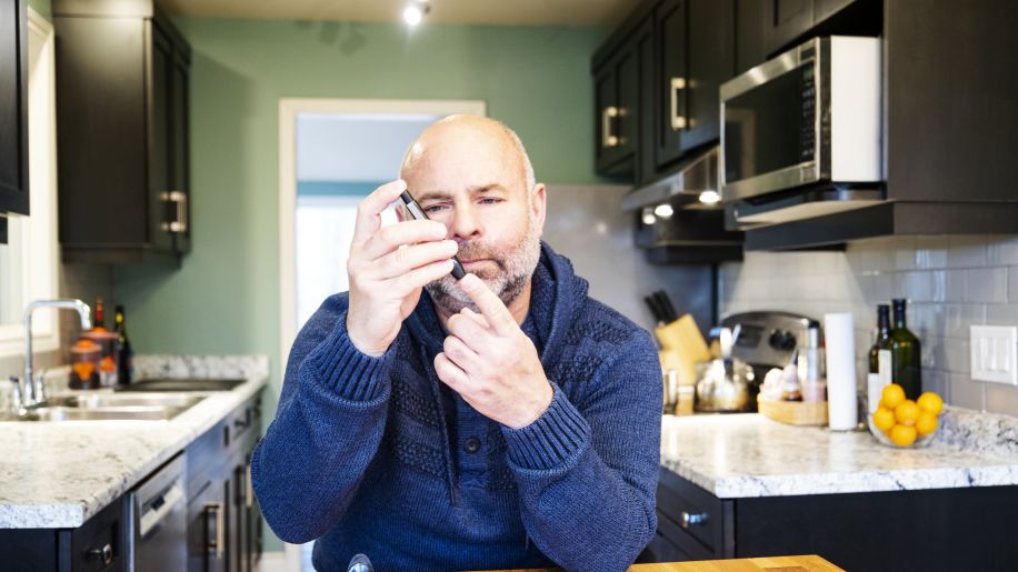 Middle-aged man taking A1C in kitchen